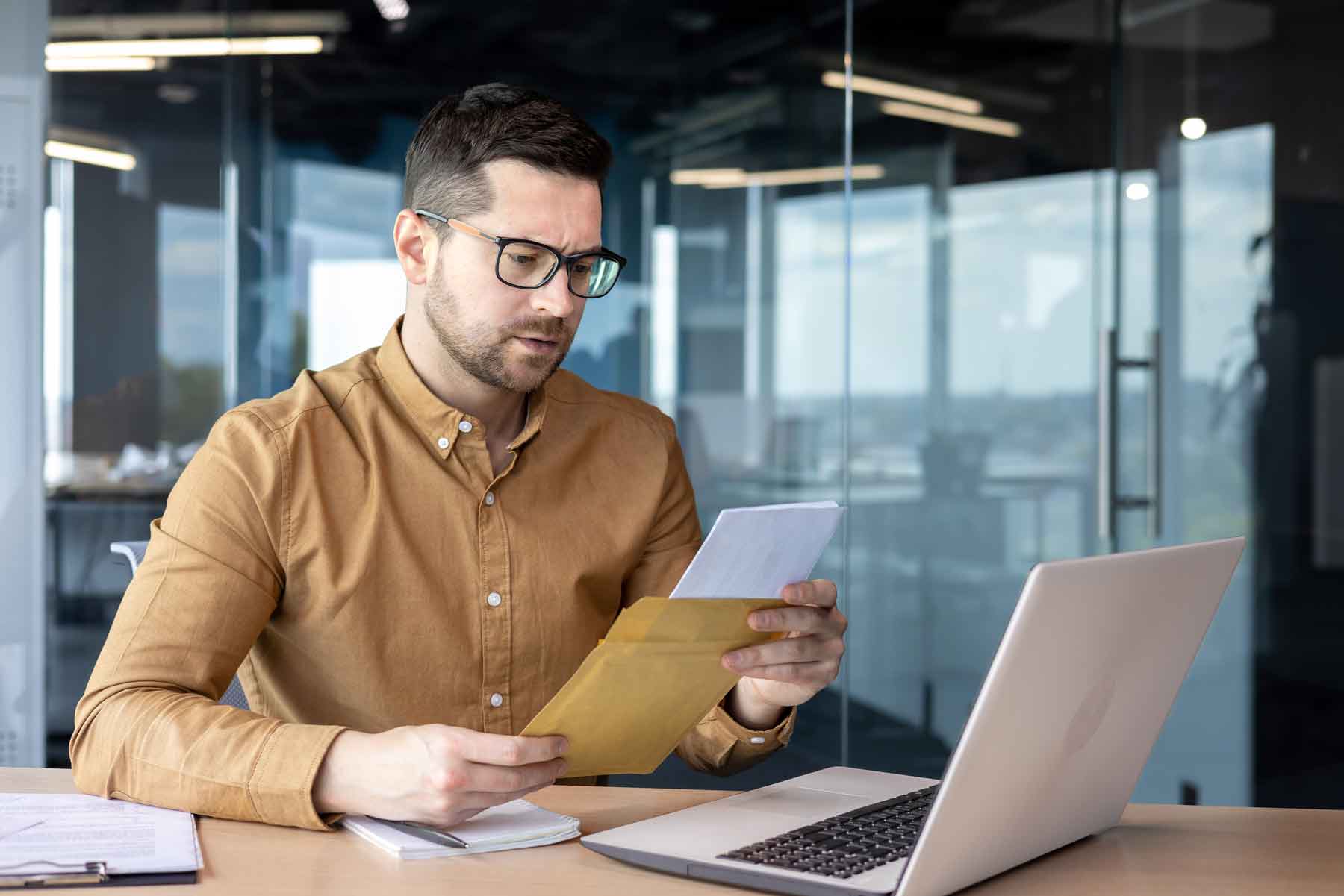 A secretary at his desk reading a letter