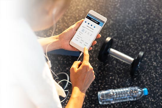 Woman at gym using Alaris app on her phone