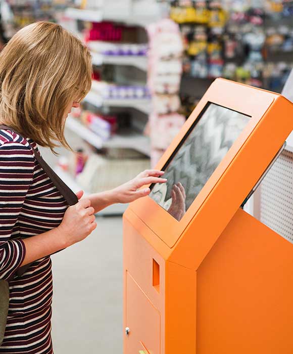 A woman using a kiosk in a home improvement store.