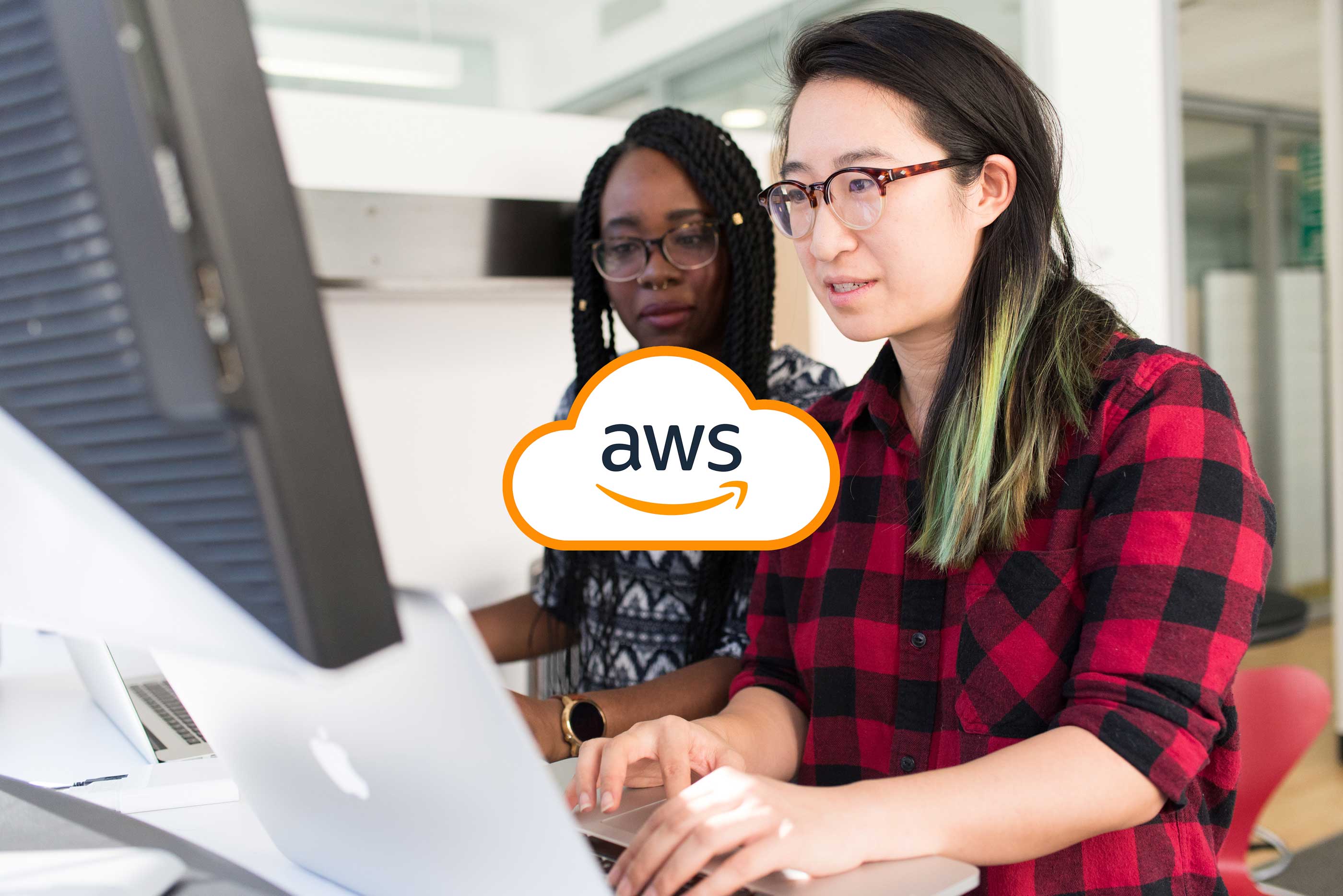Two developers coding together with the AWS logo overlaying