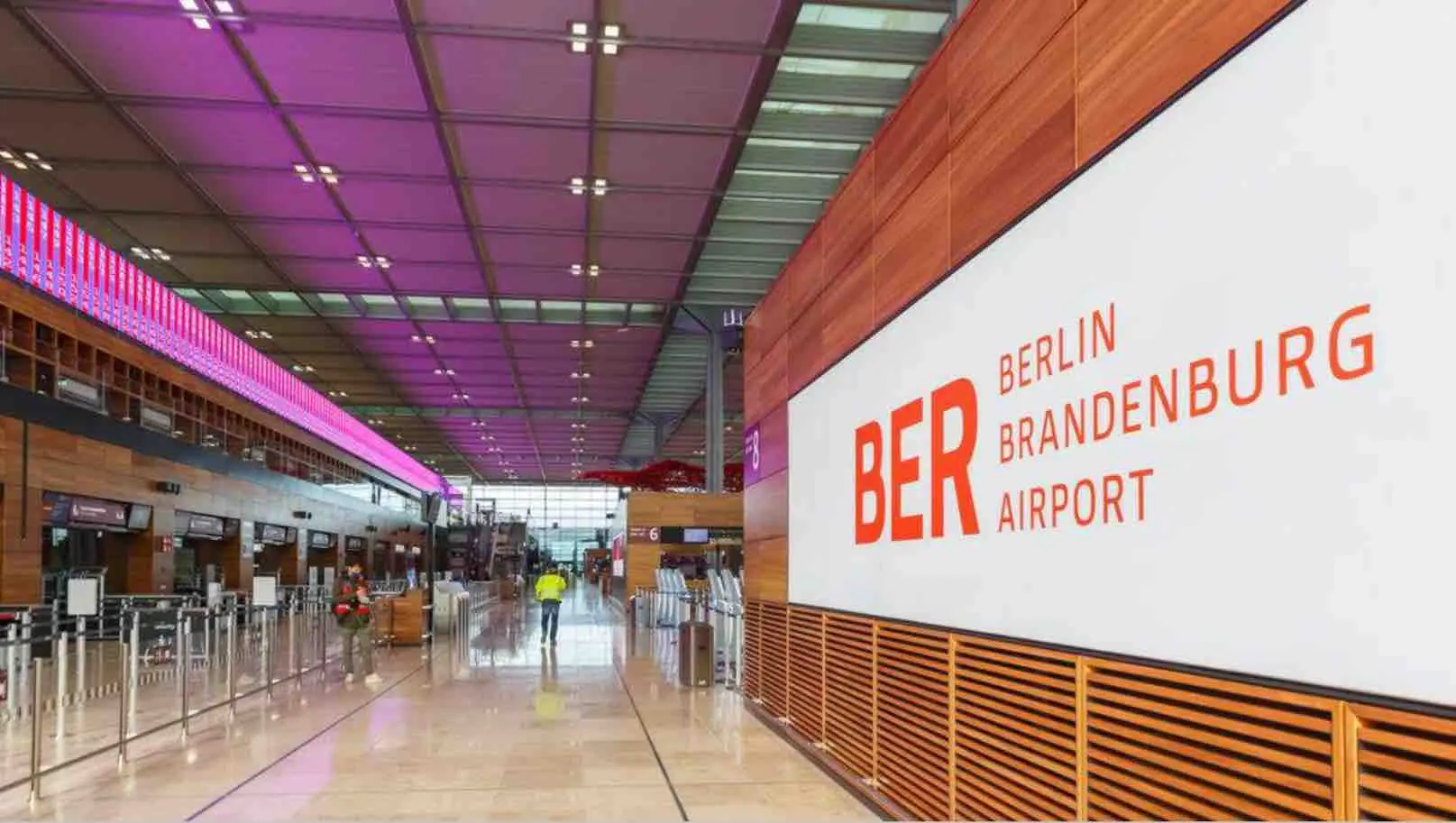 Interior of Berlin Brandenburg Airport (BER) with a large sign displaying the airport's name and terminal area.