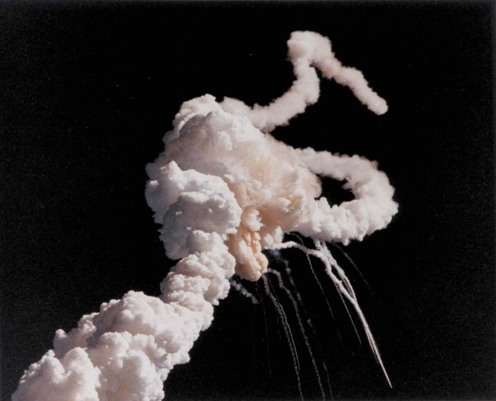 The explosion of the Space Shuttle Challenger, creating a cloud of smoke and debris in the sky.