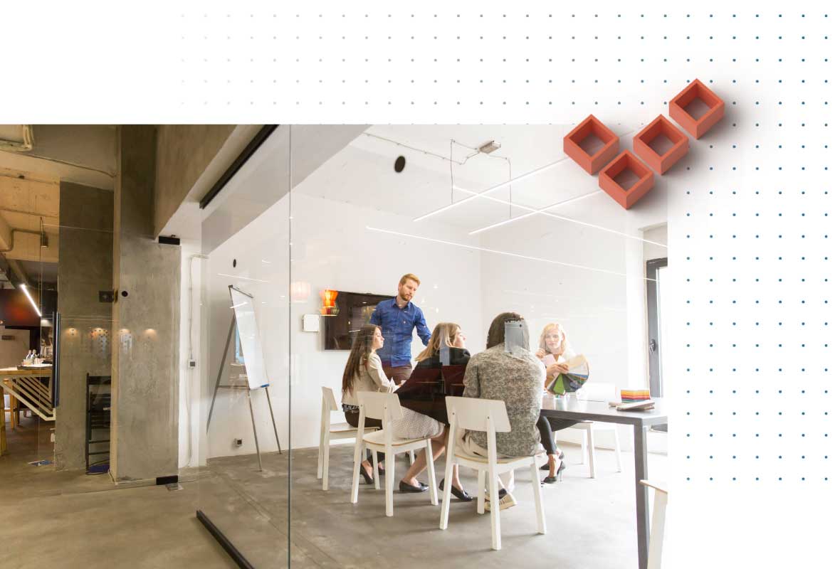 A small team of a Startup sits around a table in a meeting room.