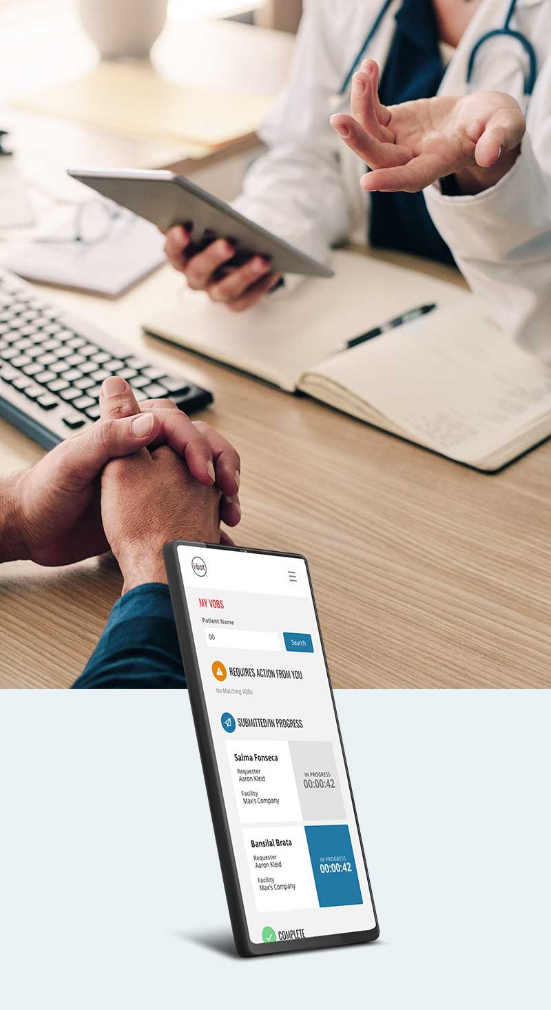 Photo of doctors hands at a desk holding a device with the patients hands folded on the other side of the desk.