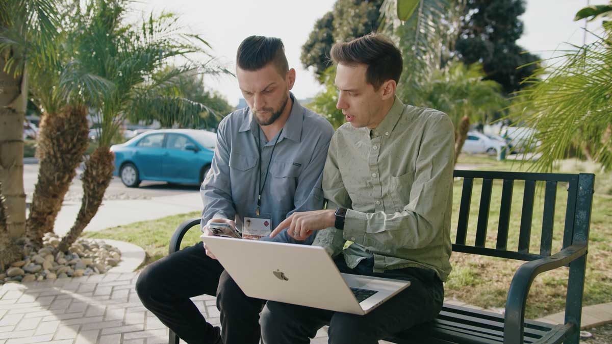 A TSG designer sitting with a client reviewing his app features.