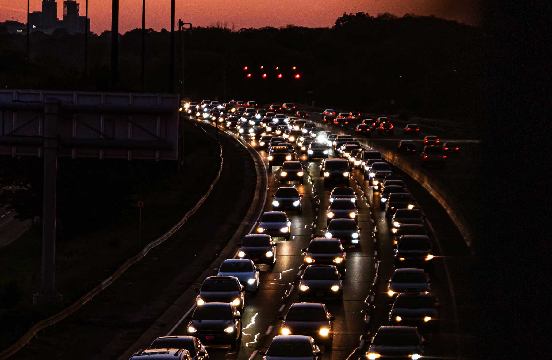 Cars stuck in city traffic during the twilight hour.