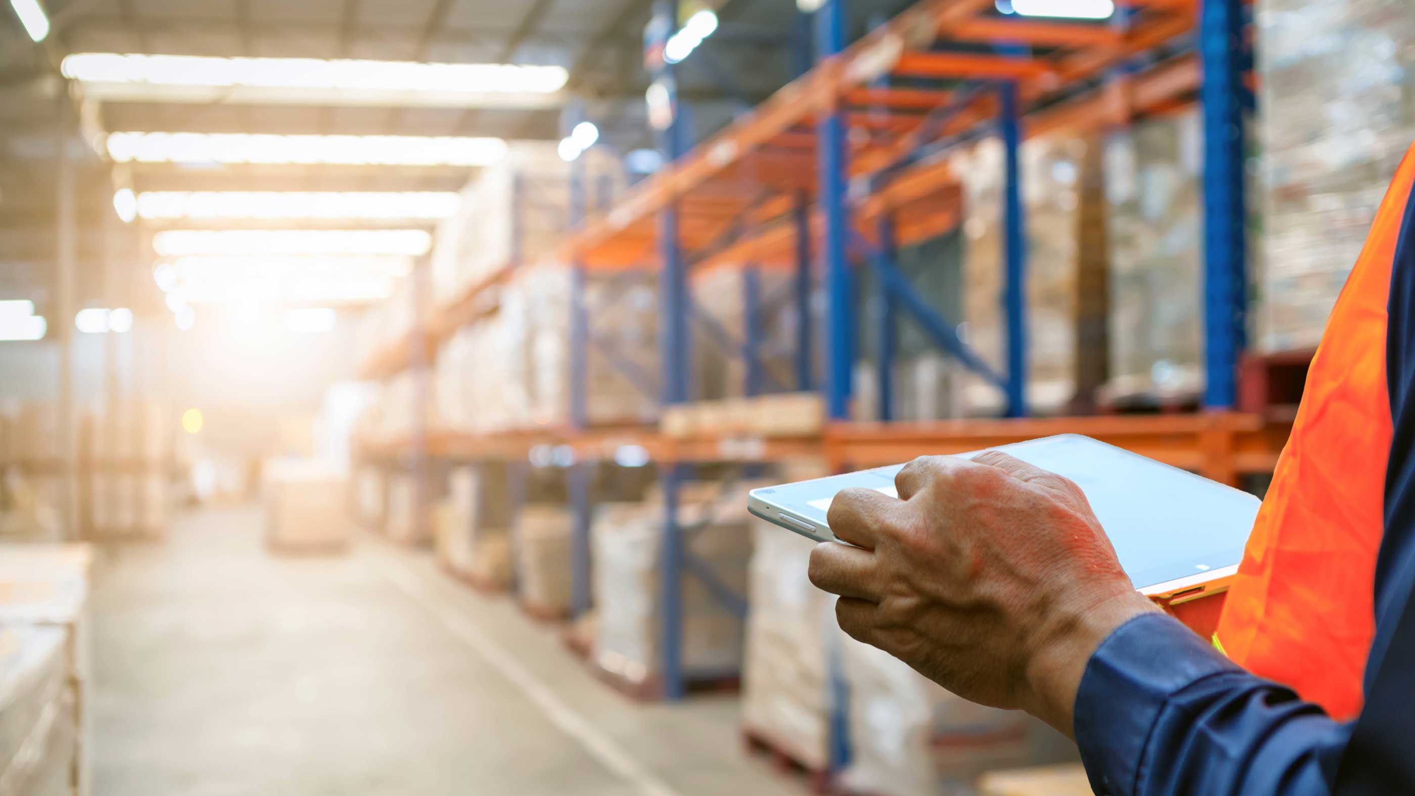 A warehouse worker using a tablet to check inventory.